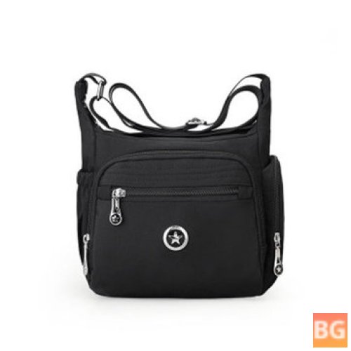 Womens shoulder bag with multiple pockets and a water resistant layer